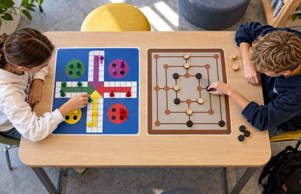 Brettspill folie 45 × 45 cm – elever som sitter rundt et brettspill i gulvfolie og spiller sammen på gulvet i skolen