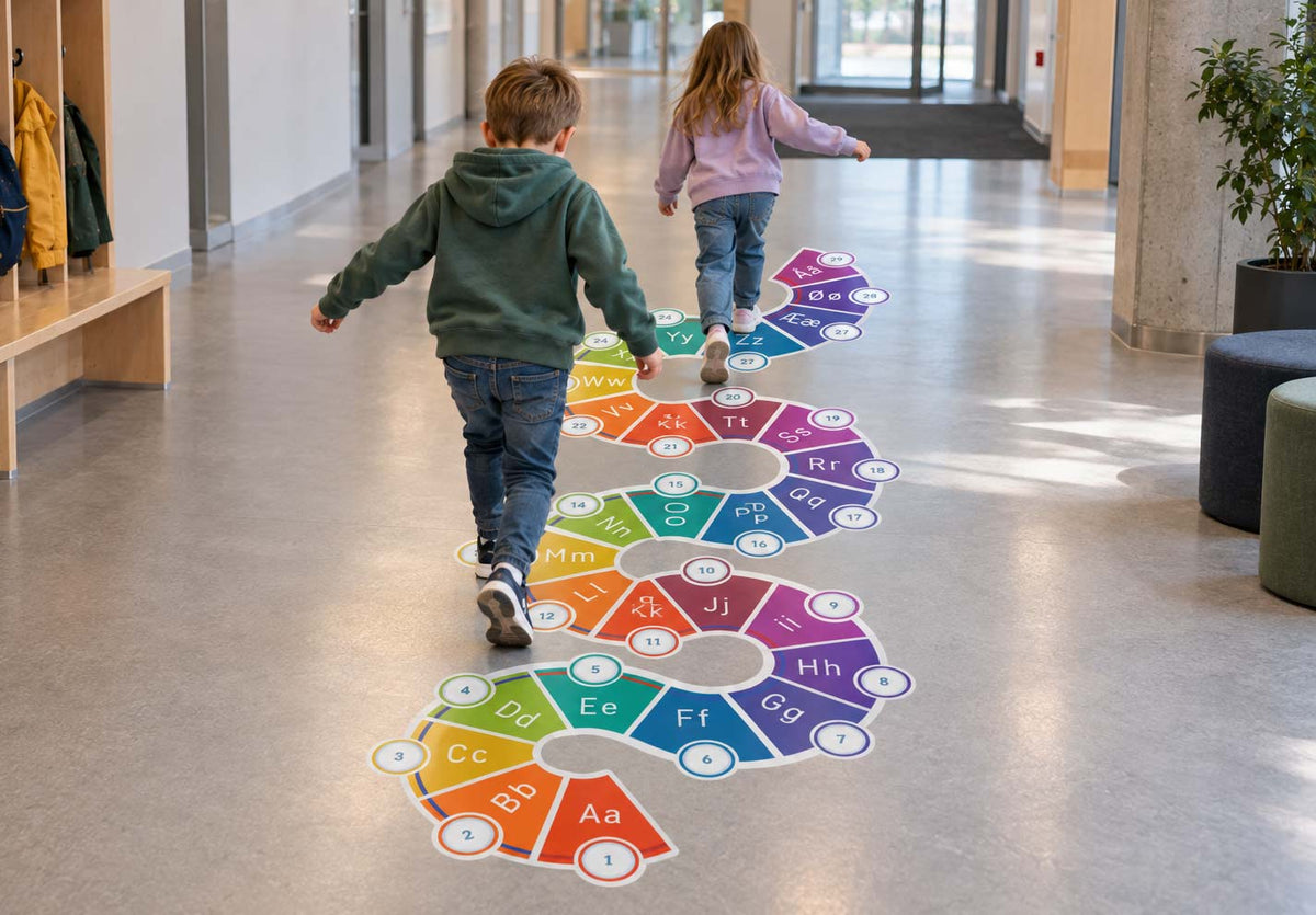 Tall- og bokstavslange – fargerik slange med tall og bokstaver som gulvdekor på skolegulvet, der barn hopper fra felt til felt